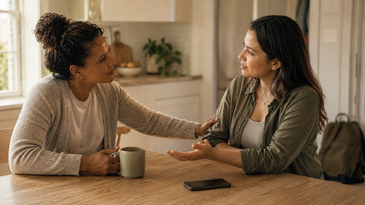 Overwhelmed parent accepting practical support from a trusted friend in a warm American home
